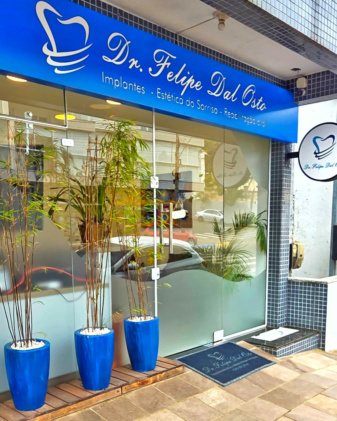 Fachada do consultório: toldo azul com o nome Dr. Felipe Dal Osto sobre a porta de vidro, na Rua Raimundo Aléssio, 631
